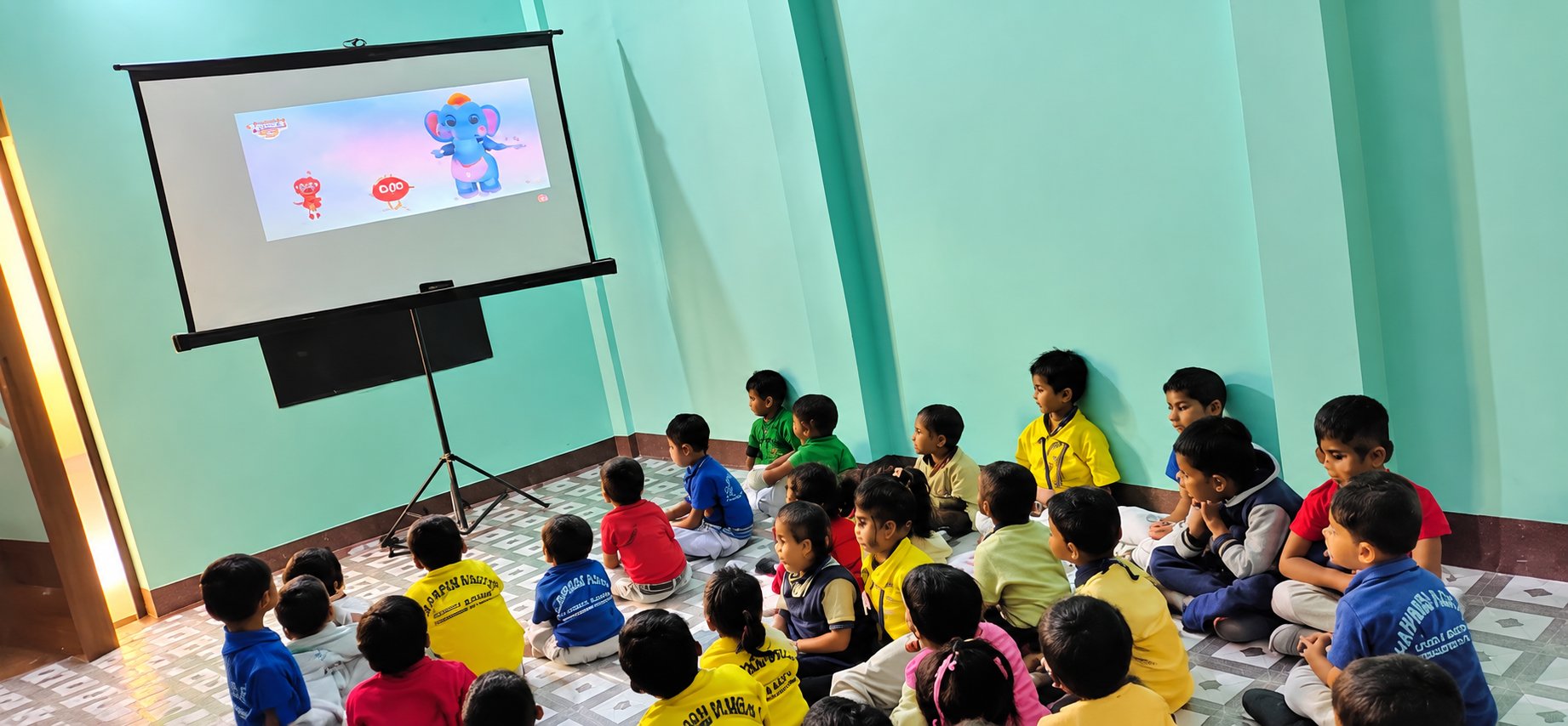 Pre Primary children watching a rhyme video together in class